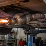 Płomienie i iskry wydobywają się z rury wydechowej samochodu podczas wypalania DPF.