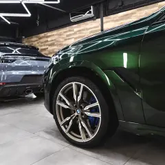 Błyszczące, zielone BMW i szare Porsche w garażu. Detailing co to? To dbałość o każdy szczegół tych luksusowych aut.