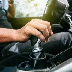 Dłoń kierowcy na dźwigni zmiany biegów. Czas na kolejny etap podróży, płynna zmiana biegów.