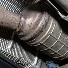 Podwozie samochodu z widocznym, skorodowanym elementem układu wydechowego, prawdopodobnie po wycięciu DPF.