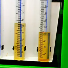 Trzy menzurki z podziałką. W dwóch widoczny żółty płyn, prawdopodobnie paliwo w oleju diesel, na poziomie ok. 50 i 40 ml.
