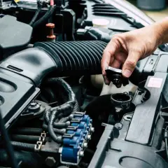 Dłoń odkręca korek zbiorniczka, pokazując, gdzie wlać płyn chłodniczy Toyota Corolla.