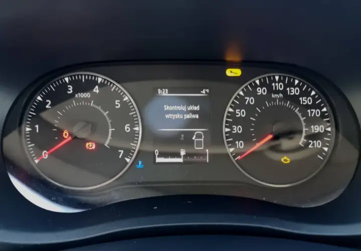 Na desce rozdzielczej Renault świeci się kontrolka "Skontroluj układ wtrysku paliwa". Obok widać wskaźniki prędkości i obrotów.