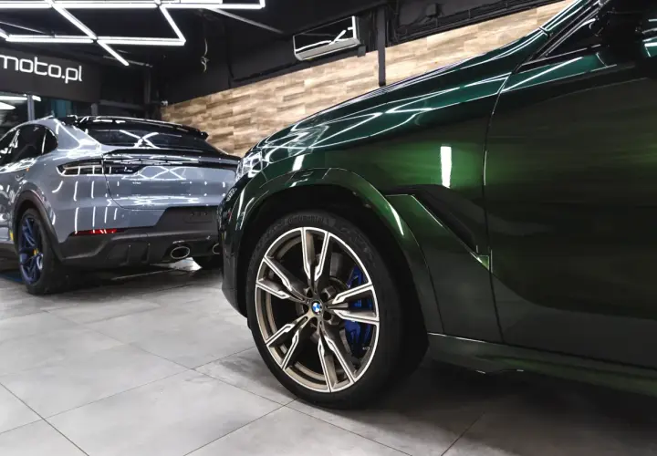 Błyszczące, zielone BMW i szare Porsche w garażu. Detailing co to? To dbałość o każdy szczegół tych luksusowych aut.