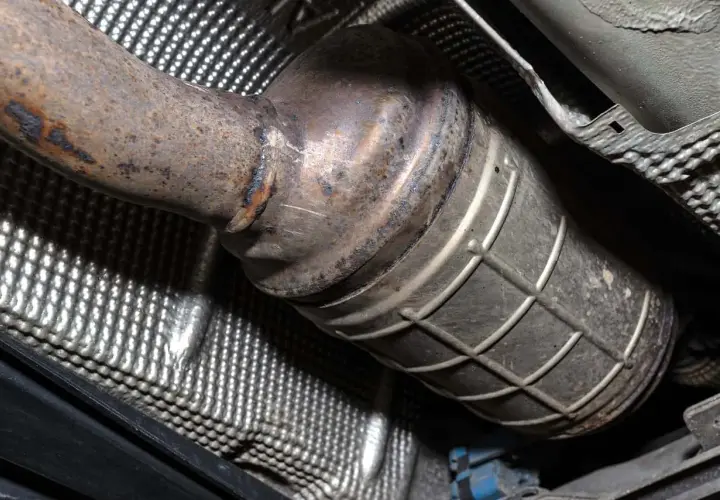 Podwozie samochodu z widocznym, skorodowanym elementem układu wydechowego, prawdopodobnie po wycięciu DPF.