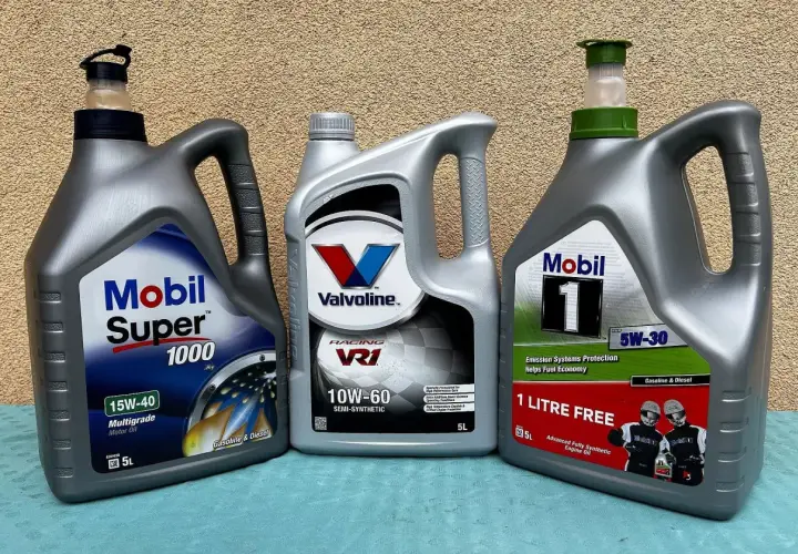 Trzy bańki oleju silnikowego: Mobil Super 1000 (mineralny), Valvoline VR1 (półsyntetyczny) i Mobil 1 (syntetyczny).