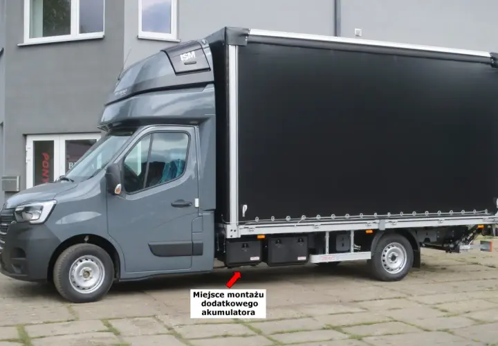 Szary Renault Master z czarnym plandeką. Miejsce montażu dodatkowego akumulatora znajduje się pod drzwiami pasażera.