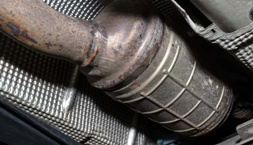 Podwozie samochodu z widocznym, skorodowanym elementem układu wydechowego, prawdopodobnie po wycięciu DPF.