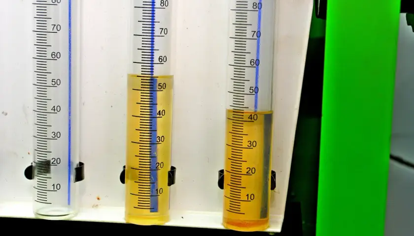 Trzy menzurki z podziałką. W dwóch widoczny żółty płyn, prawdopodobnie paliwo w oleju diesel, na poziomie ok. 50 i 40 ml.