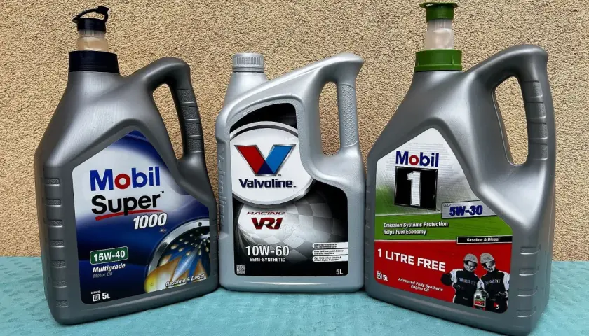 Trzy bańki oleju silnikowego: Mobil Super 1000 (mineralny), Valvoline VR1 (półsyntetyczny) i Mobil 1 (syntetyczny).
