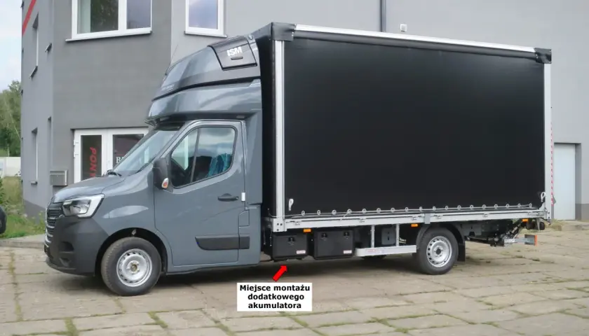 Szary Renault Master z czarnym plandeką. Miejsce montażu dodatkowego akumulatora znajduje się pod drzwiami pasażera.