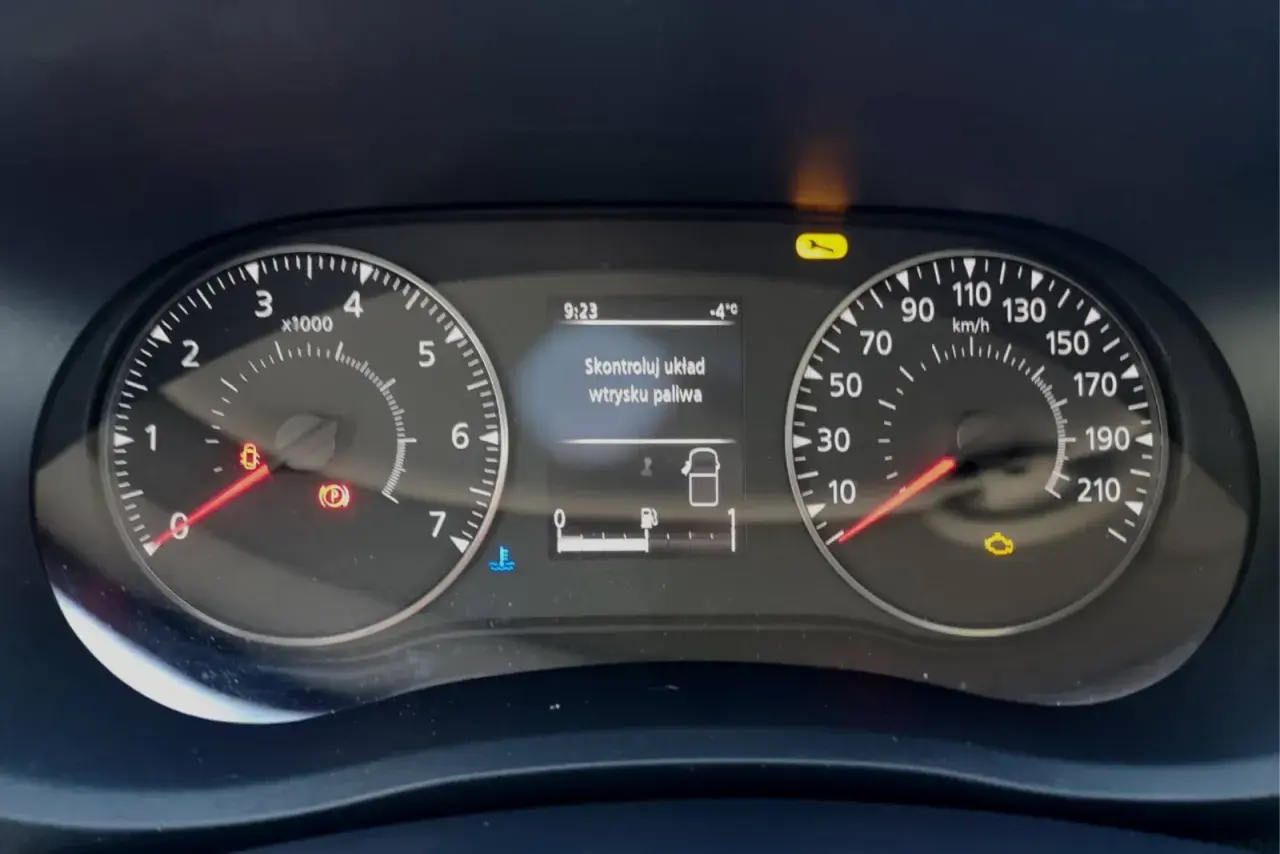 Na desce rozdzielczej Renault świeci się kontrolka "Skontroluj układ wtrysku paliwa". Obok widać wskaźniki prędkości i obrotów.