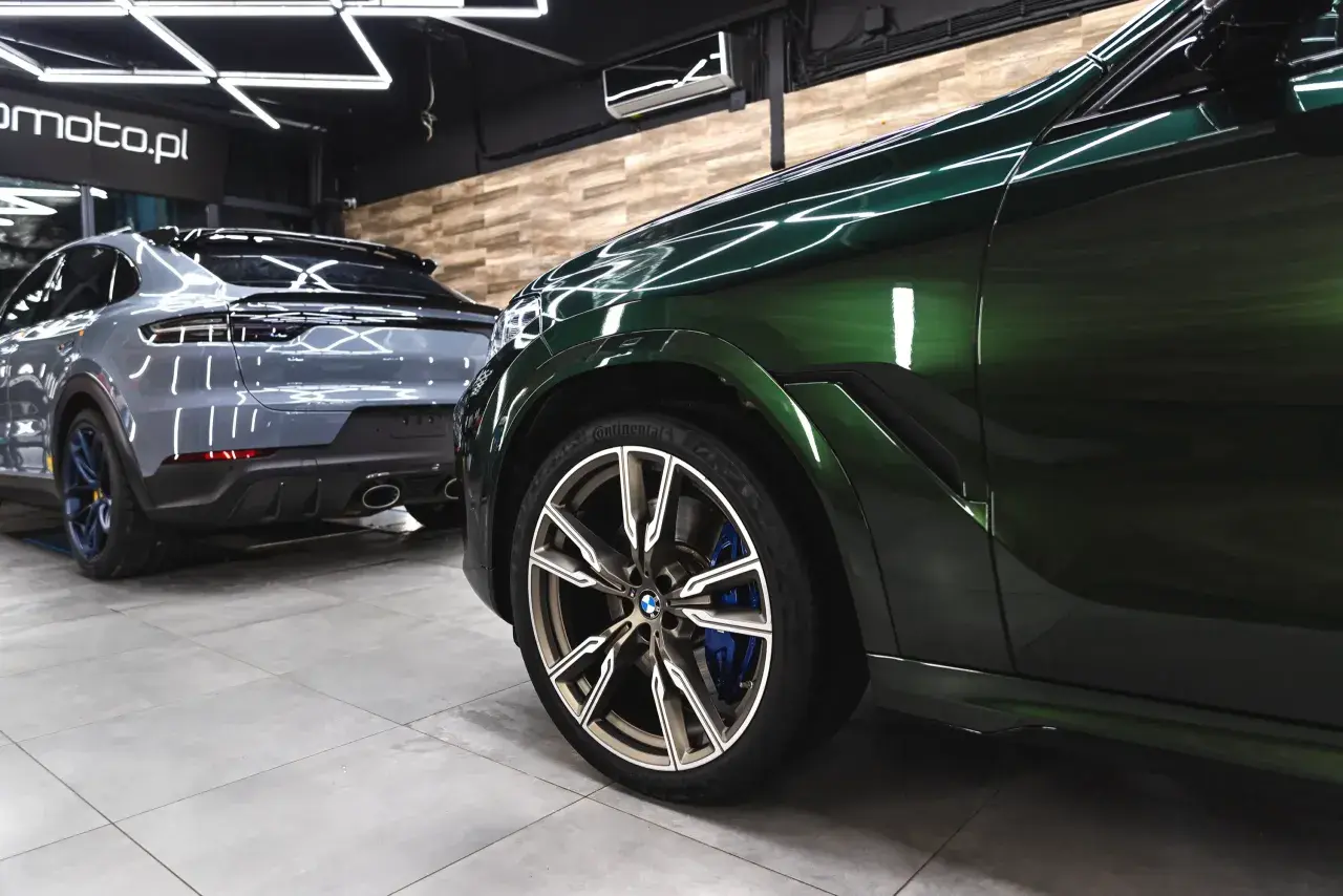 Błyszczące, zielone BMW i szare Porsche w garażu. Detailing co to? To dbałość o każdy szczegół tych luksusowych aut.