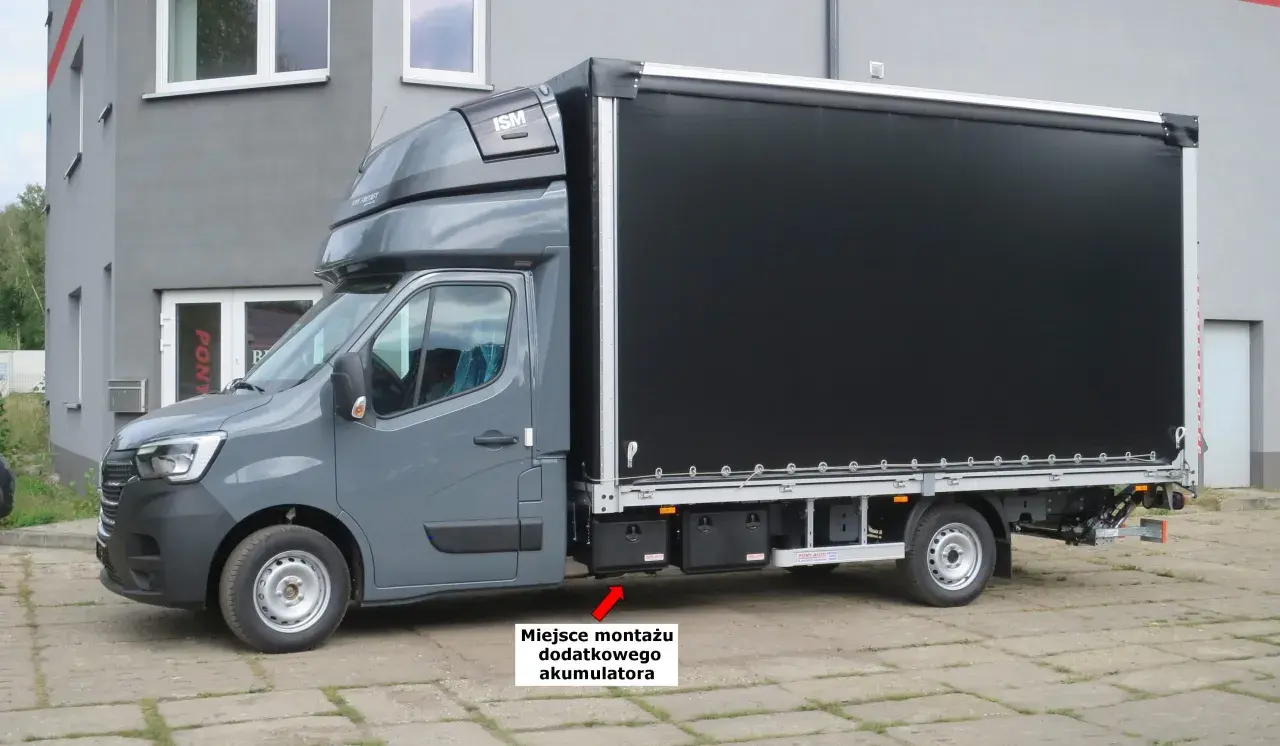 Szary Renault Master z czarnym plandeką. Miejsce montażu dodatkowego akumulatora znajduje się pod drzwiami pasażera.