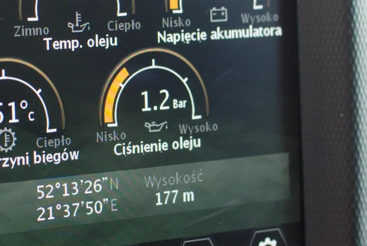 Wskaźnik pokazuje prawidłowe ciśnienie oleju w silniku benzynowym: 1.2 Bar. Obok widać temperaturę oleju 51°C.