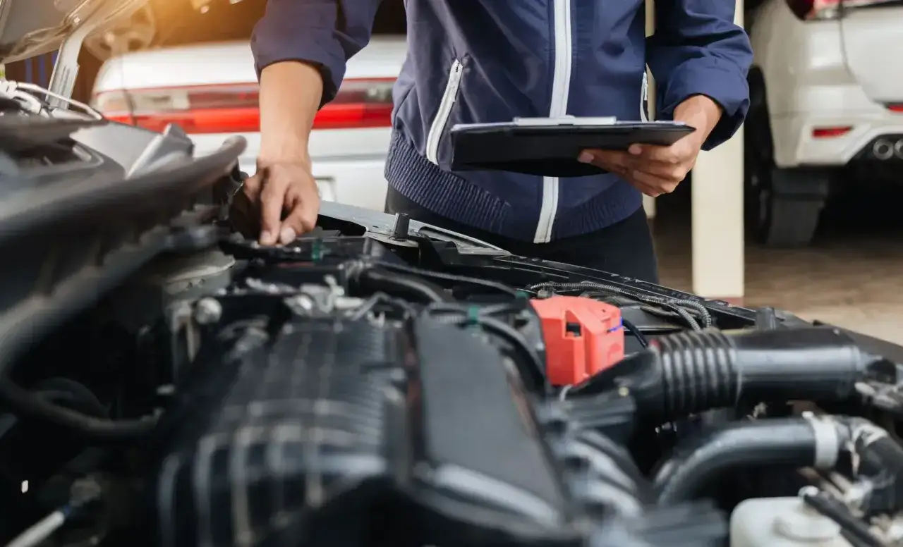 Mechanik sprawdza układ wtrysku paliwa Renault, notując obserwacje na tablecie.