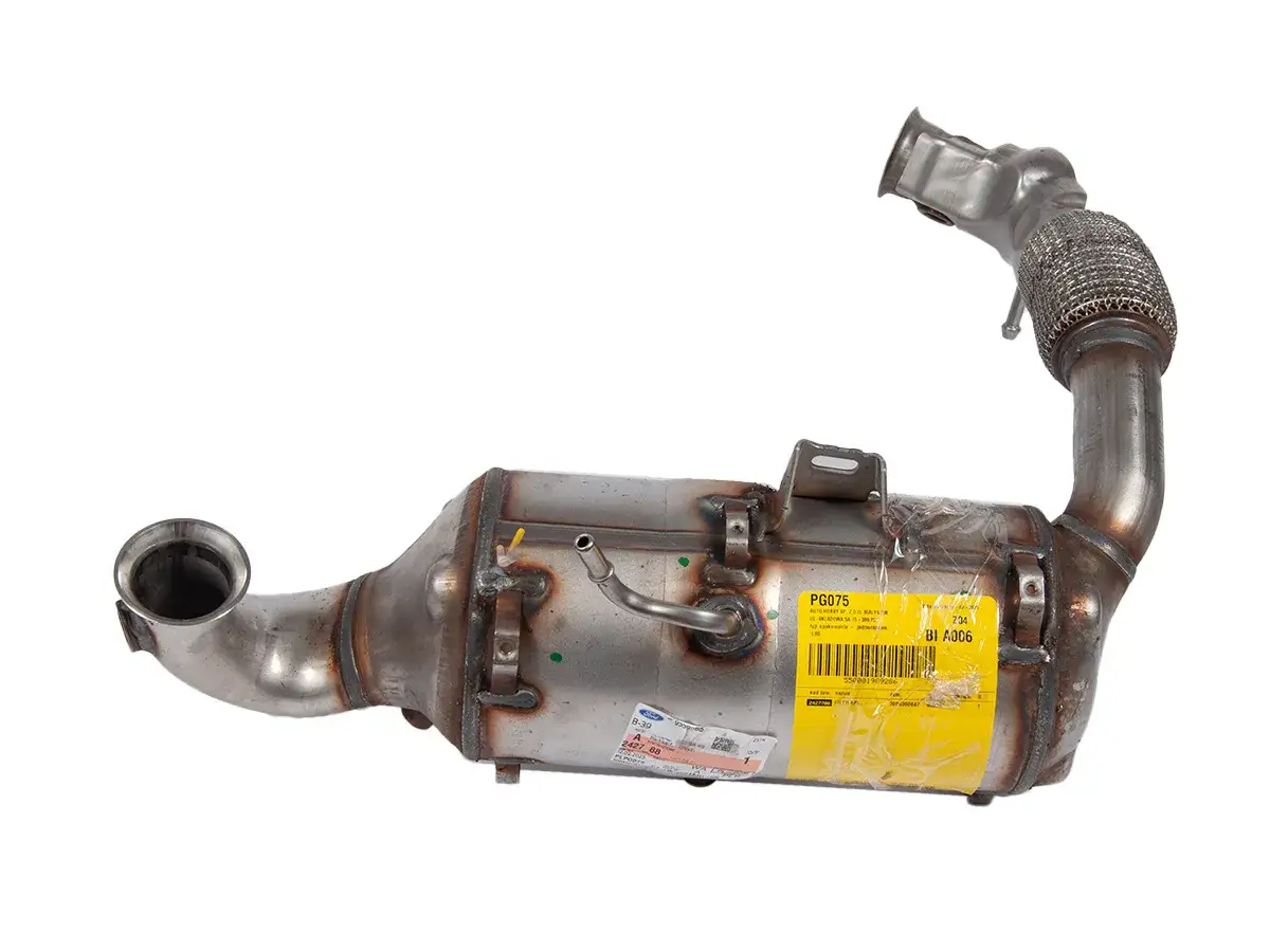 Metalowy element układu wydechowego, prawdopodobnie katalizator a dpf, z żółtą naklejką z oznaczeniami.
